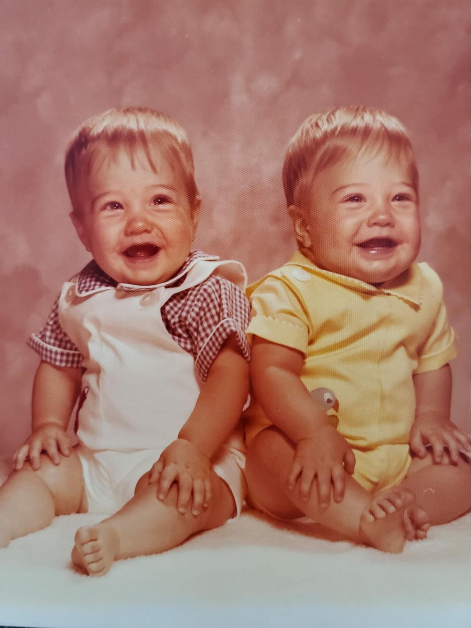 Zac and Jacob as babies, sitting side by side in a studio portrait